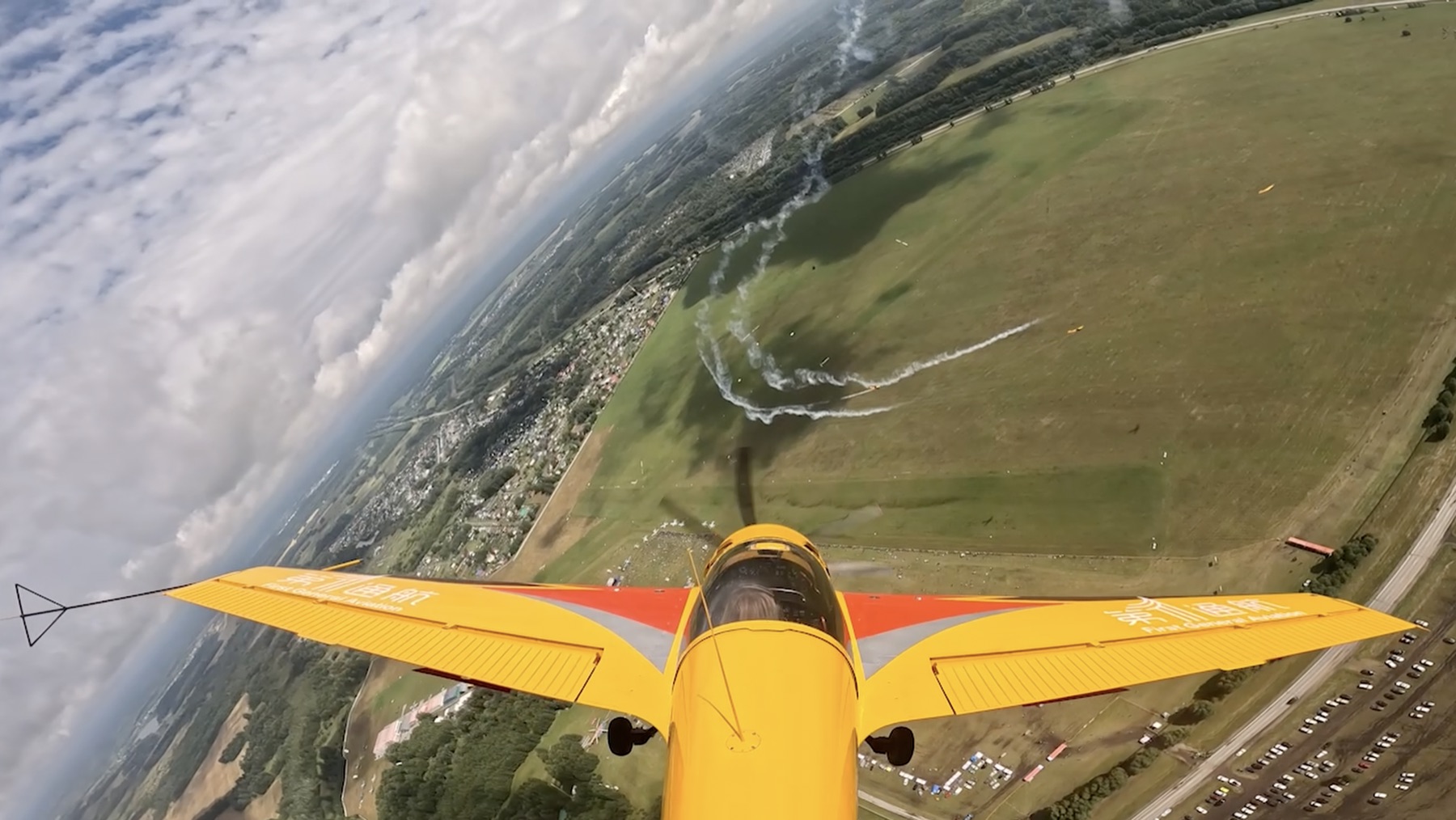 View from a yellow aerobatic aircraft above an airfield