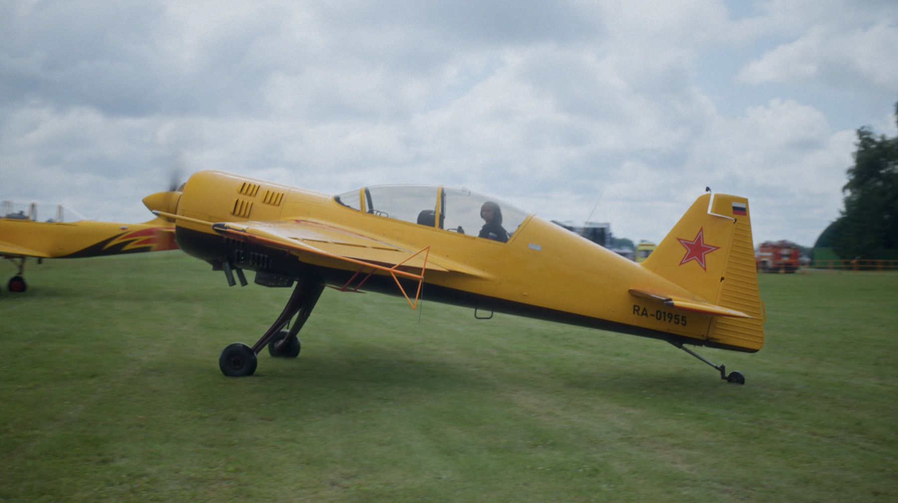 Yellow aerobatic aircraft on an airfield