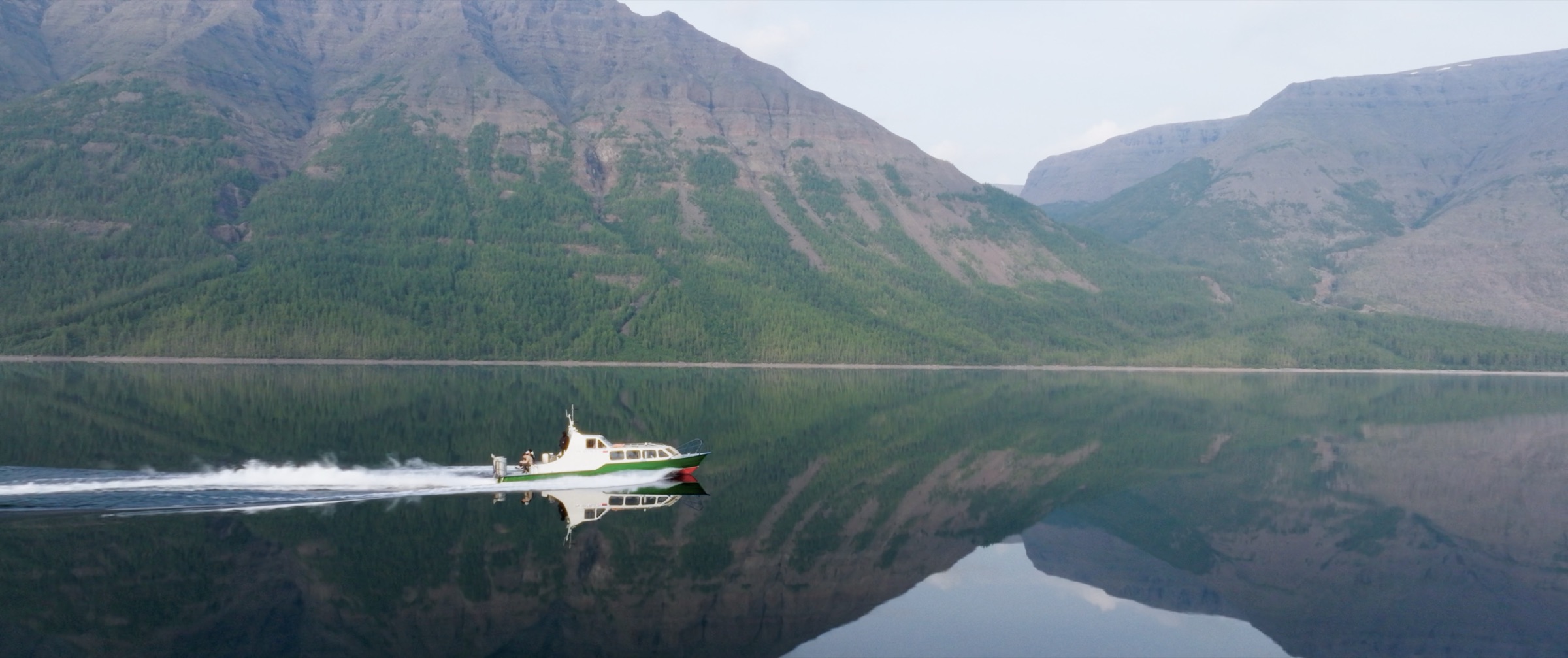 Motorboat crossing a mountain lake on the Putorana Plateau